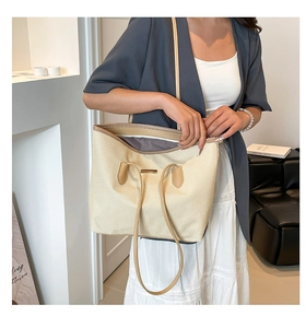 Close-up of beige woven tote bag showing spacious interior with dark gray lining