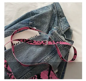 Detail of pink and black snakeskin strap with adjustable silver metal pin buckle
