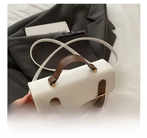 Detail showing the white PU leather handbag with contrasting brown straps and gold buckle
