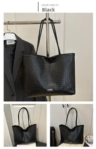 Detail of black woven large capacity tote bag with fashion label for daily commuting