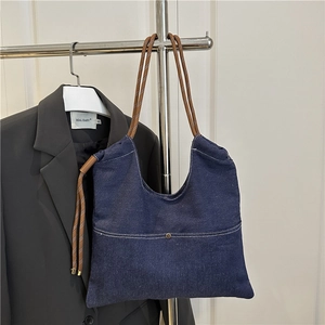 Minimalist dark blue denim tote bag with brown woven handles for summer casual use