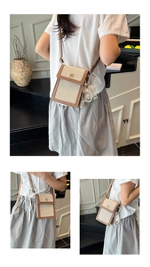 Detailed view of color block phone bag with clover logo and pearl chain strap