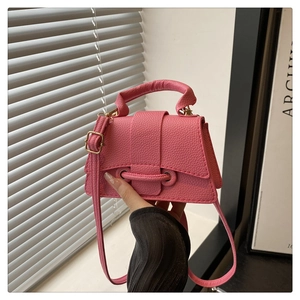 Close-up of pink litchi grain mini square bag with unique perforated strap detail