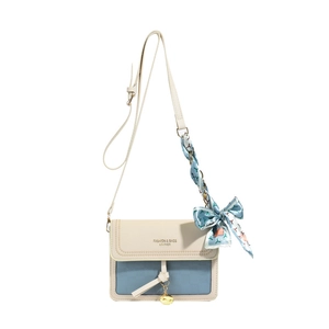 Modern two-tone rectangular crossbody bag with blue silk scarf accent and gold pendant