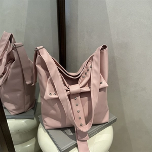 Pink bow bucket tote bag with silver studs and matte PU leather finish in mirror setting