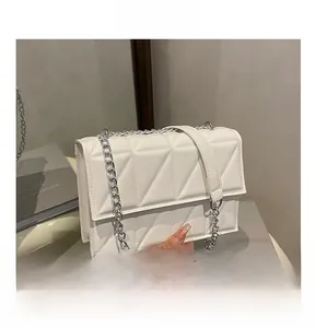 Detailed macro view of white PU leather crossbody bag with geometric triangle stitching