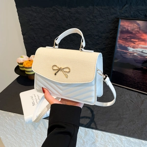 White quilted crossbody bag with woven flap and golden butterfly clasp hardware