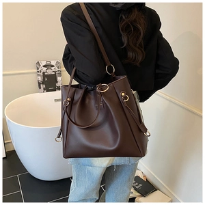 Detail of coffee brown tote bag with gold ring hardware and soft faux leather texture