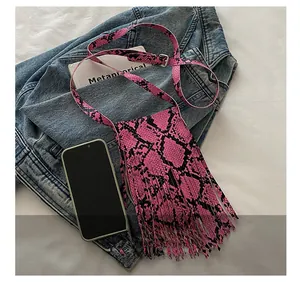 Detail of pink snake skin crossbody bag with long tassels and stylish PU leather texture