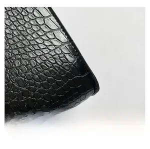 Macro shot of high-quality black crocodile-patterned leather with glossy finish