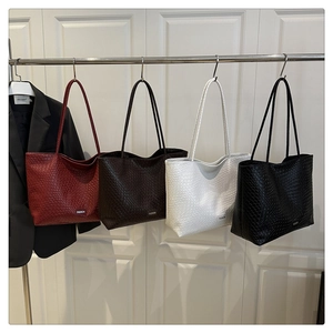 Detail view of four large woven tote bags in burgundy, coffee, white and black colors
