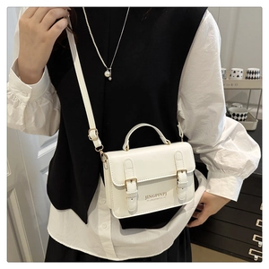 Detailed side view of white matte PU leather square handbag with adjustable strap on model