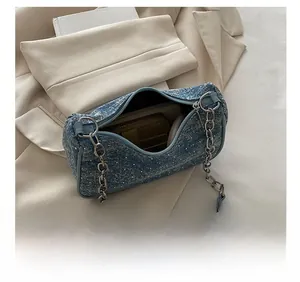 Detailed view of rhinestone denim underarm bag showing interior capacity and silver chain
