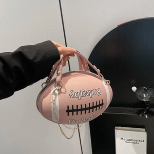 Roze handtas in de vorm van een rugbybal met witte strepen en een gouden ketting