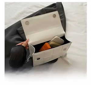 Top view of open white quilted chain bag showing interior capacity for phone and makeup