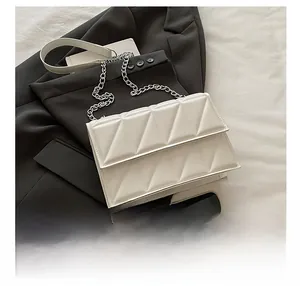Top view of white quilted chain bag showing size comparison with a mobile phone