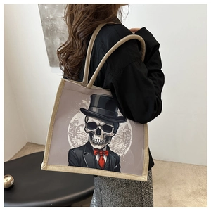 Détail du sac cabas en toile avec illustration de crâne gothique et bordures tressées