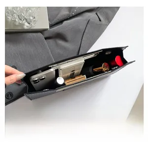 Internal view of crocodile pattern handbag showing space for smartphone and makeup