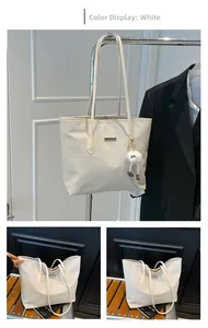 Dettaglio della borsa tote bianca con trama intrecciata e ciondolo in peluche incluso