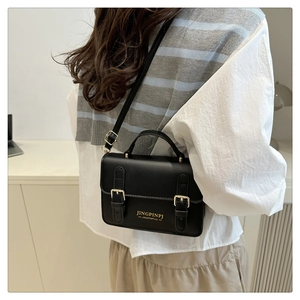 Detailed side view of a black PU leather small square bag with decorative gold buckles