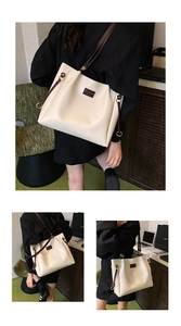 Detail view of large cream tote bag with dark brown straps and gold metal hardware