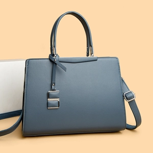 Détail d'un sac à main en cuir bleu-gris avec finitions argentées et bandoulière amovible