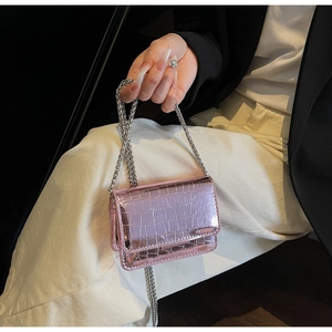 Detail of pink crocodile embossed patent leather mini bag with silver chain strap
