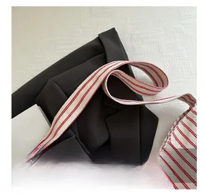 Macro view of a red and white striped canvas tote bag with a durable woven handle strap