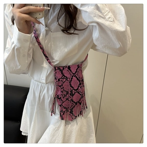 Close-up of pink and black snakeskin print crossbody bag with long tassel fringe detail