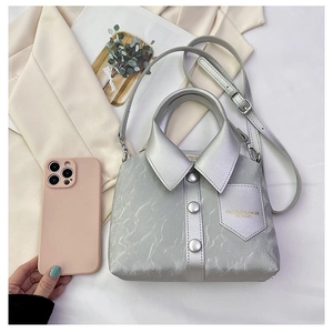 Detail of silver shirt-shaped handbag with pleated texture and adjustable strap