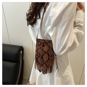 Detail of snake print crossbody bag with stylish long fringes and slim shoulder strap