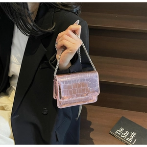 Detail of pink croc-embossed mini bag with metallic finish and silver chain strap