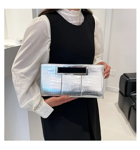 Detailed macro view of silver crocodile pattern clutch bag with metallic texture