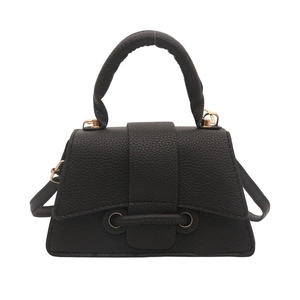 Minimalist black trapezoid handbag with lychee texture and light gold hardware