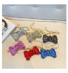 Dettaglio delle mini borse a fiocco in acrilico con finiture metallizzate argento e oro
