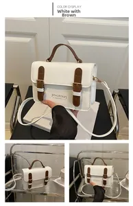 Detail view of the white and coffee vintage shoulder bag with gold hardware and strap