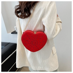 Red heart-shaped crossbody bag featuring detailed black spiderweb embroidery and gold chain