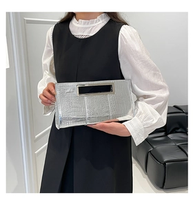 Close-up of silver crocodile texture clutch bag with rectangular metal handle