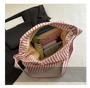 Macro view of spacious striped canvas tote bag showing interior storage for daily items