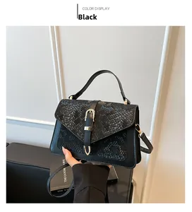 Close-up of black crossbody bag featuring snakeskin texture flap and metal buckle closure