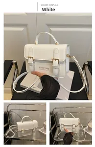 Detail view of a white PU leather rectangular handbag with belt buckles and top handle