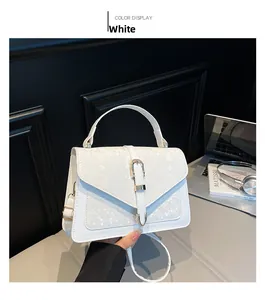 Detail of white snakeskin texture handbag with metal buckle and top handle