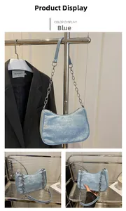 Detail of light blue sequined baguette bag with silver chain strap and zipper closure