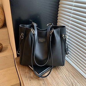 Minimalist large black tote bag in textured faux leather with golden metal hardware