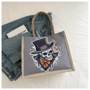 Détail du sac cabas gris en toile avec motif de gentleman squelette et nœud papillon