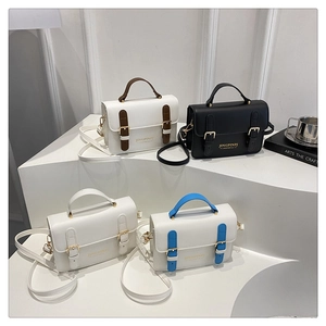 Chic small crossbody bags in four colors arranged on steps in a minimalist studio setting
