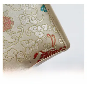 Macro detail of embroidered cloud and butterfly patterns on a Chinese style bucket bag
