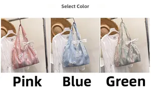 Vue détaillée des sacs fourre-tout à broderie florale en rose, bleu et vert pastel