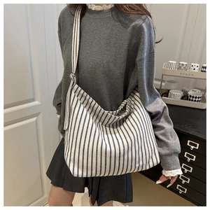 Close-up of striped canvas tote bag showing textured fabric and wide shoulder strap