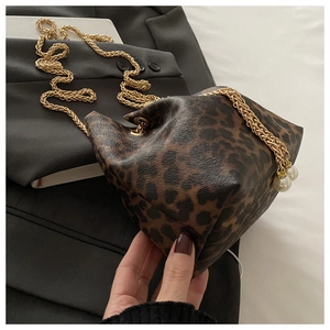 Detail of leopard print bucket bag featuring gold chain strap and elegant pearl charms